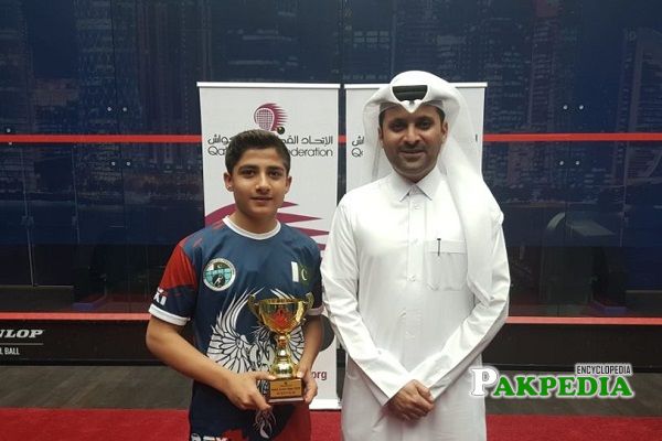 Champion of Squash Hamza Khan holding his trophy