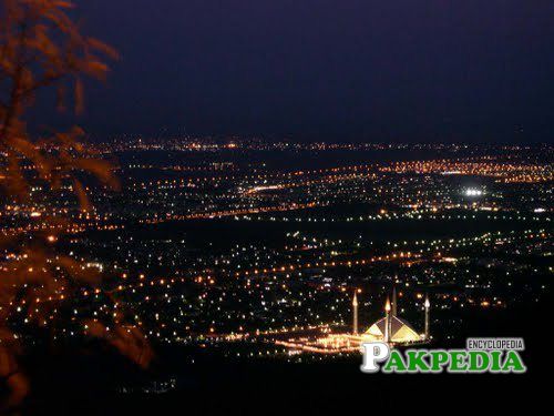 A scenic view of the city from the Margalla Hills at night